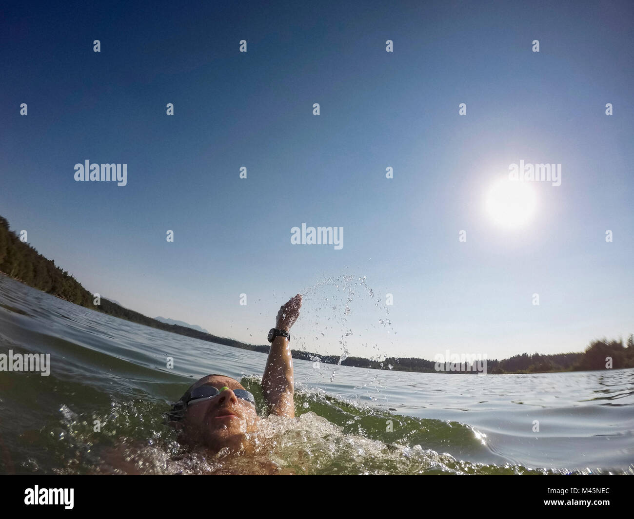 Uomo maturo nuoto dorso sul lago, vicino fino Foto Stock