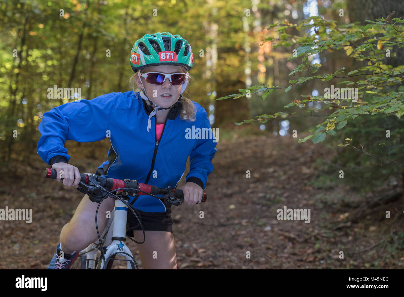 Ragazza mountain biker preparando a ciclo nel bosco Foto Stock