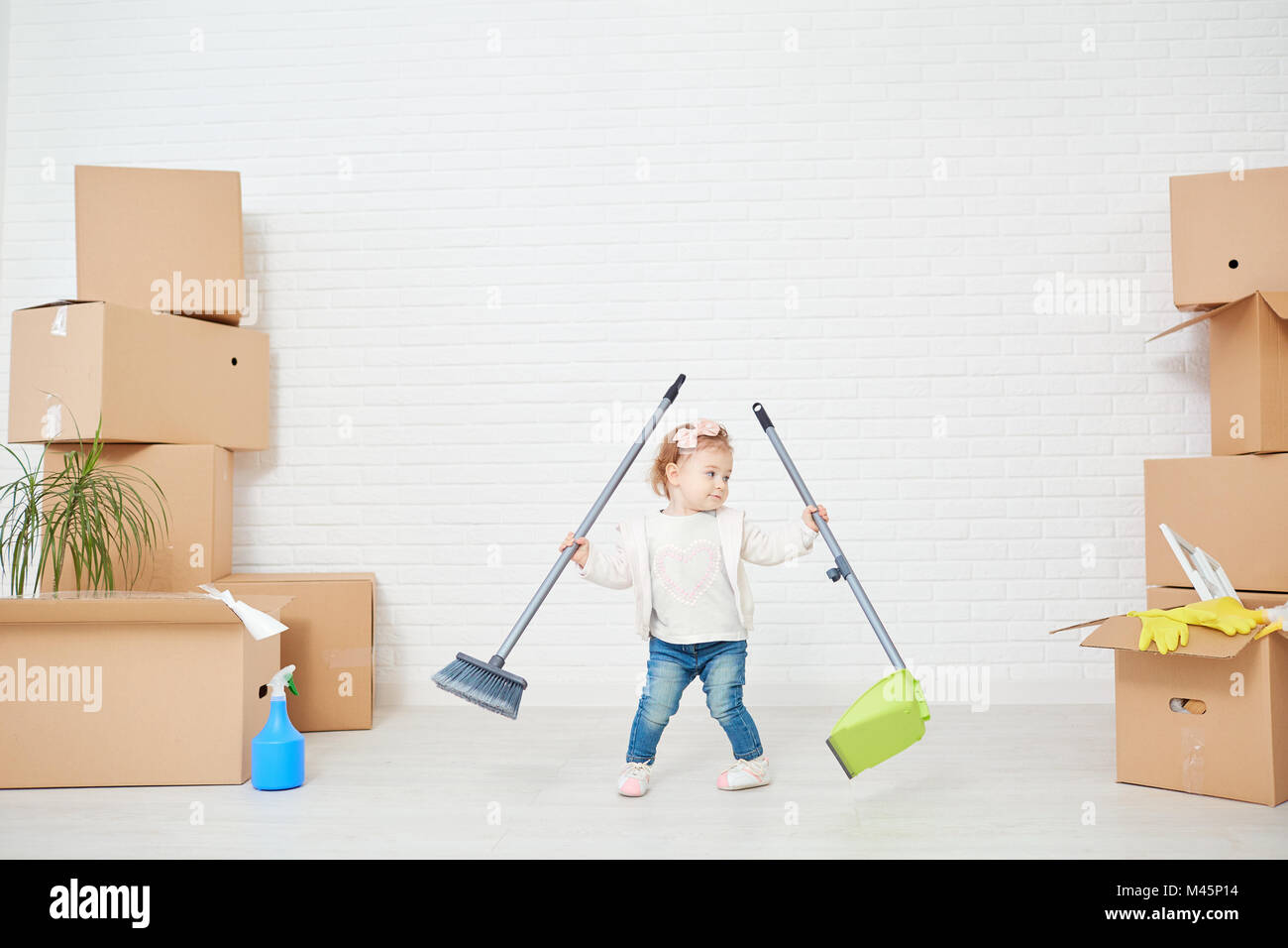 Un divertente bambino fa la pulizia in casa Foto Stock