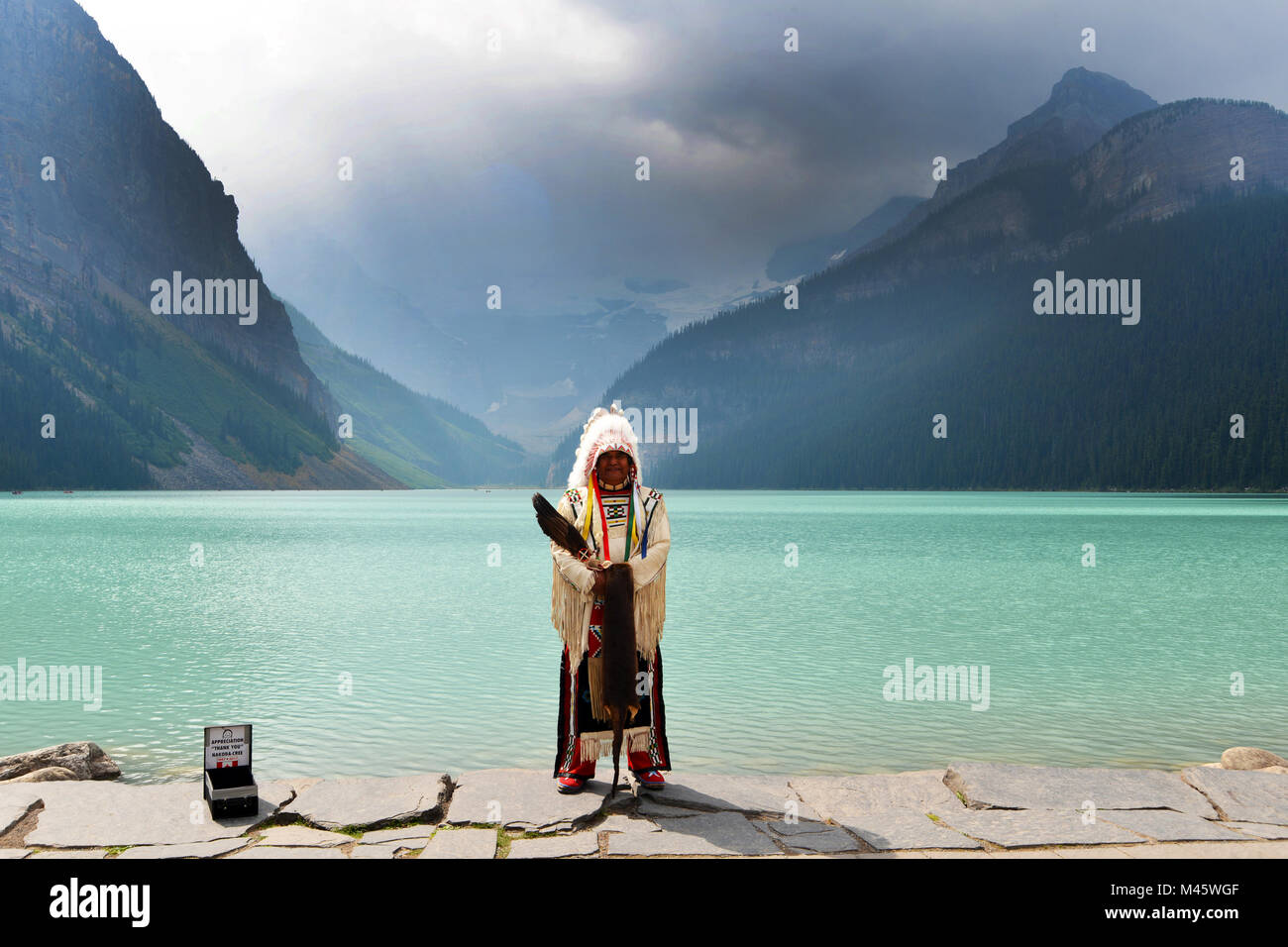 Una prima nazione nativa uomo canadese pone per foto turistiche presso il Lago Louise, Montagne Rocciose Canadesi Foto Stock