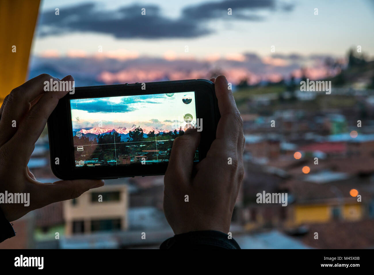 Vista di una persona che ha preso una foto con il loro cellulare della Cordillera Huaywash da un alto edificio in Chiquian, Perù. Foto Stock