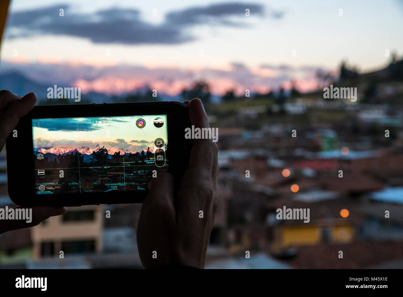 Vista di una persona che ha preso una foto con il loro cellulare della Cordillera Huaywash da un alto edificio in Chiquian, Perù. Foto Stock