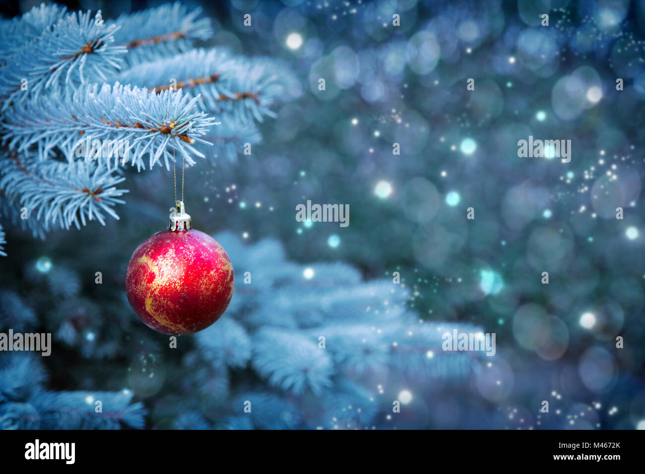 Rosso palla di Natale isolati su grigio sfondo bokeh di fondo. Foto Stock