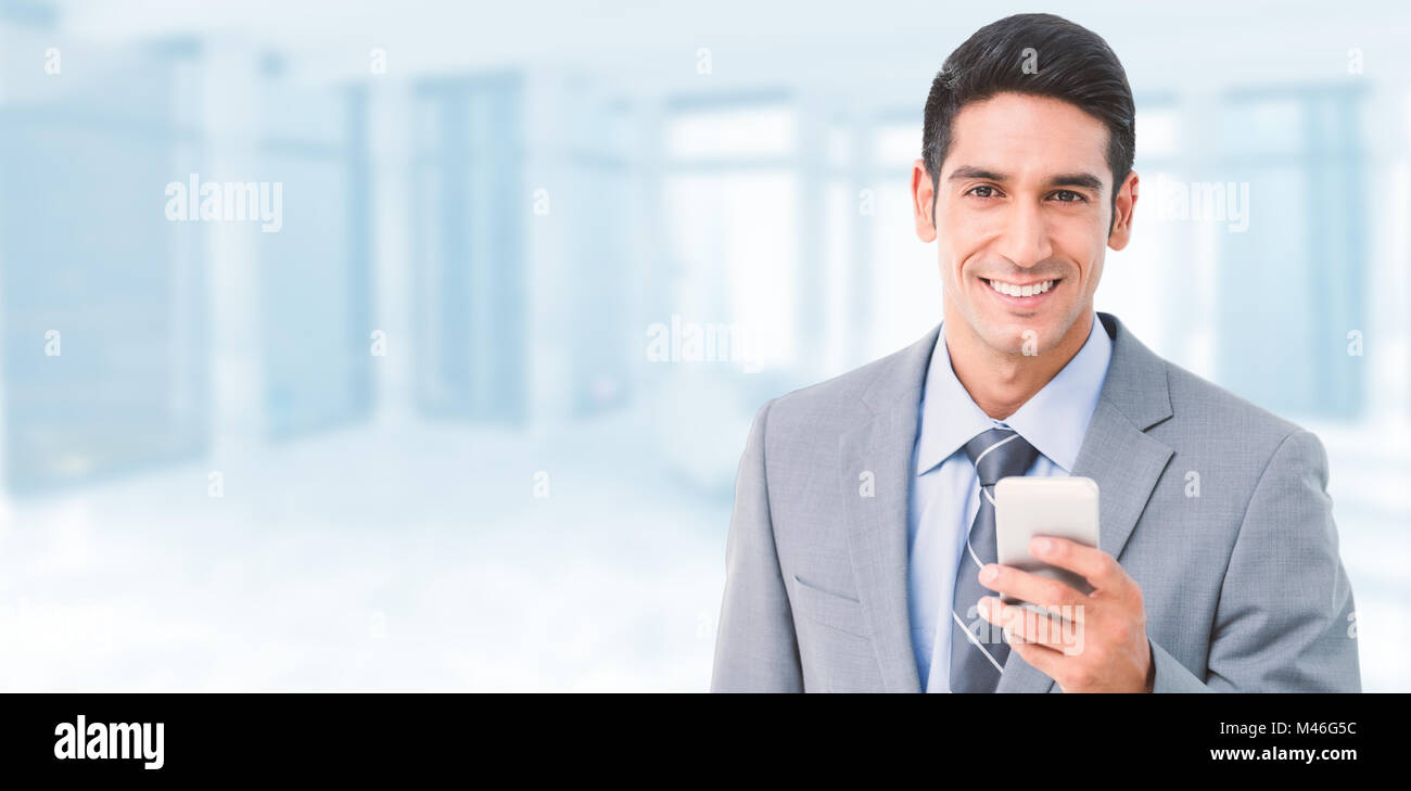 Immagine composita di imprenditore utilizzando il telefono cellulare con i colleghi dietro Foto Stock