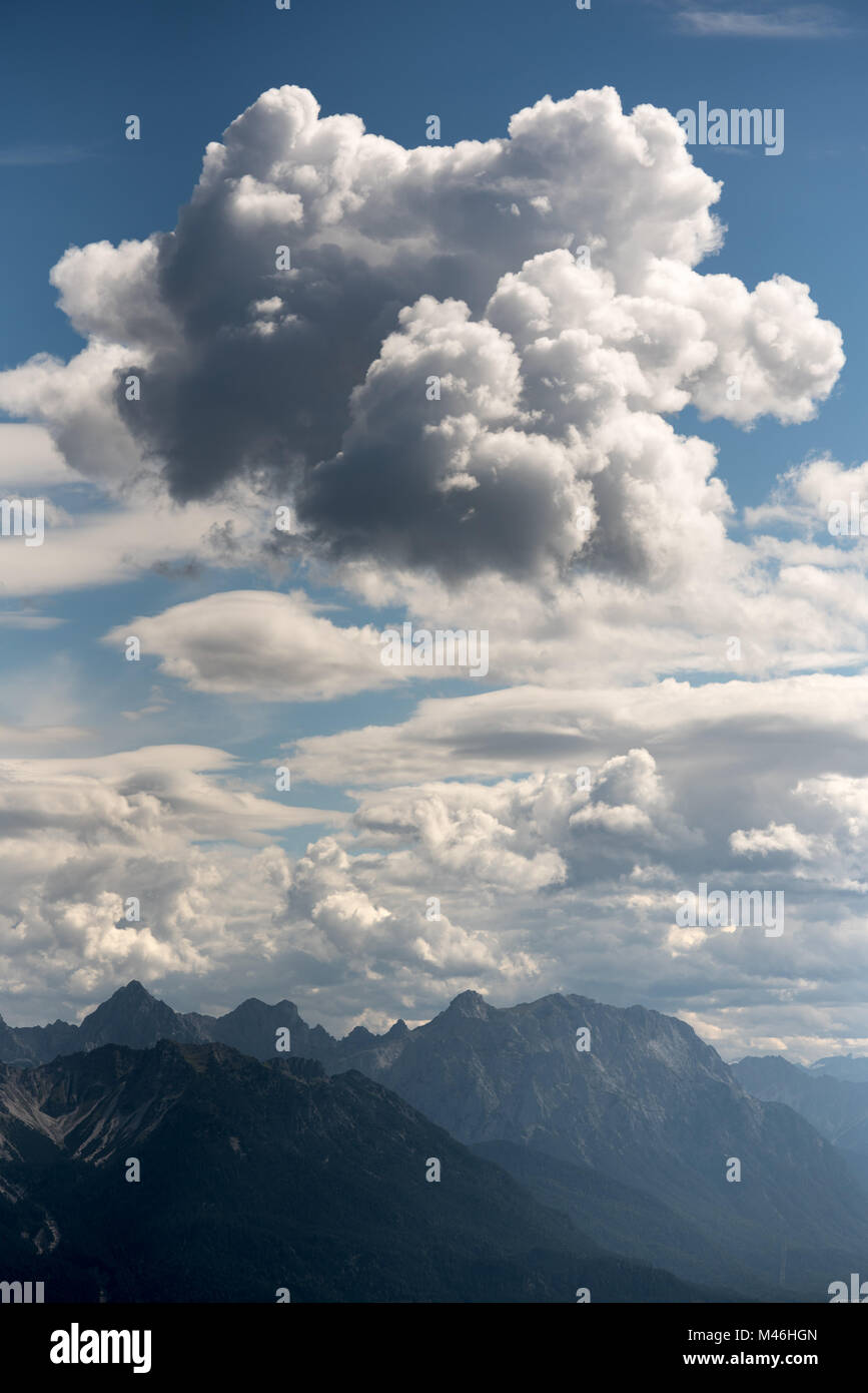Grandi e soffici cumulus cloud sopra cime di montagna Foto Stock