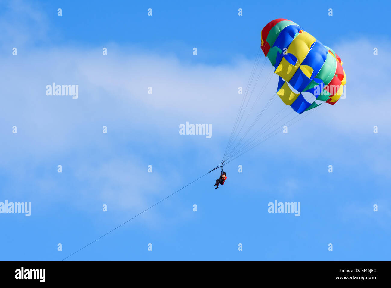 Turisti che si godono il parasailing in un cielo blu di Roatan, Honduras. Foto Stock