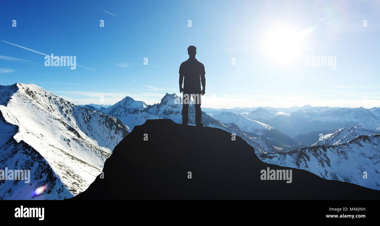 Silhouette di un uomo in piedi sulla cima della montagna durante il periodo invernale Foto Stock