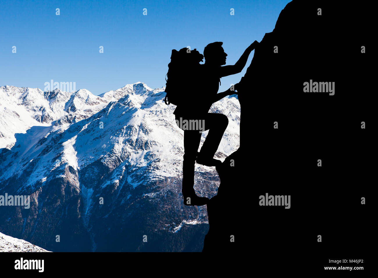Silhouette di un uomo Arrampicata in montagna durante il periodo invernale Foto Stock