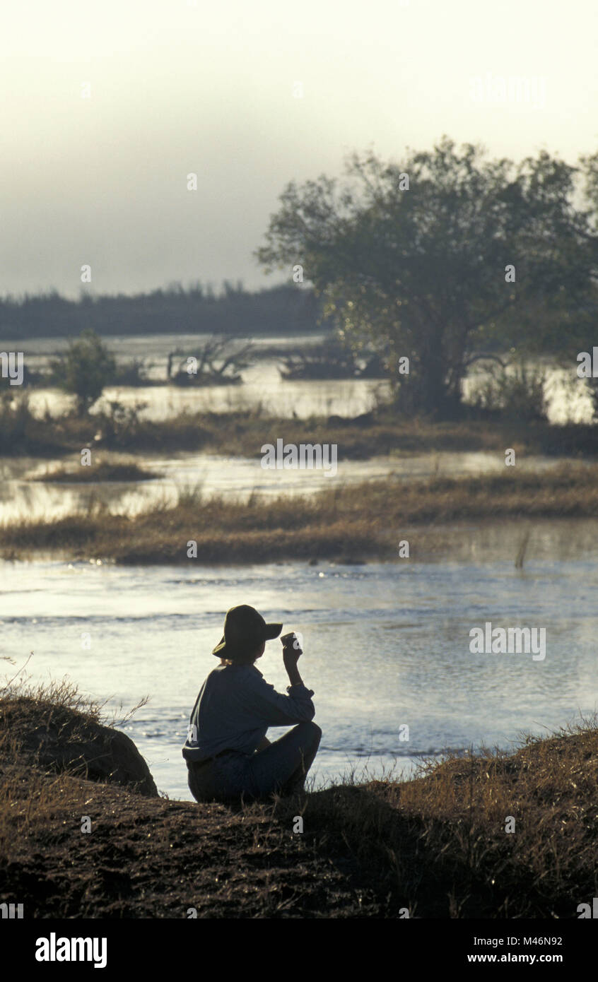 Lo Zimbabwe. Vicino a Victoria Falls. Fiume Zambesi. Sunrise. I turisti. Donna di bere. Foto Stock