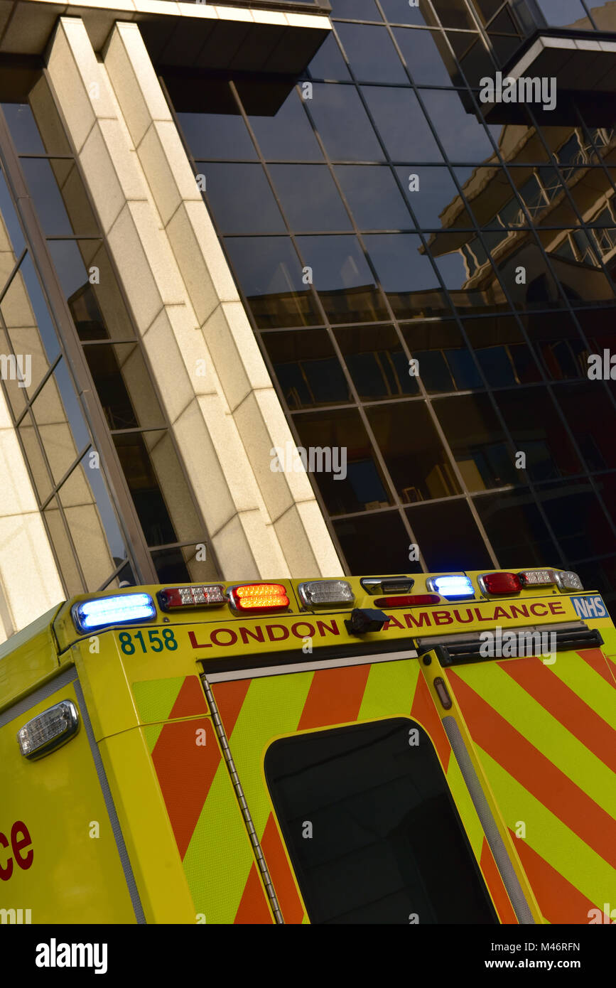 Un'emergenza amulance nel centro di Londra con luci lampeggianti per partecipare a una chiamata 999 in un ufficio commerciale area di business della capitale. Foto Stock