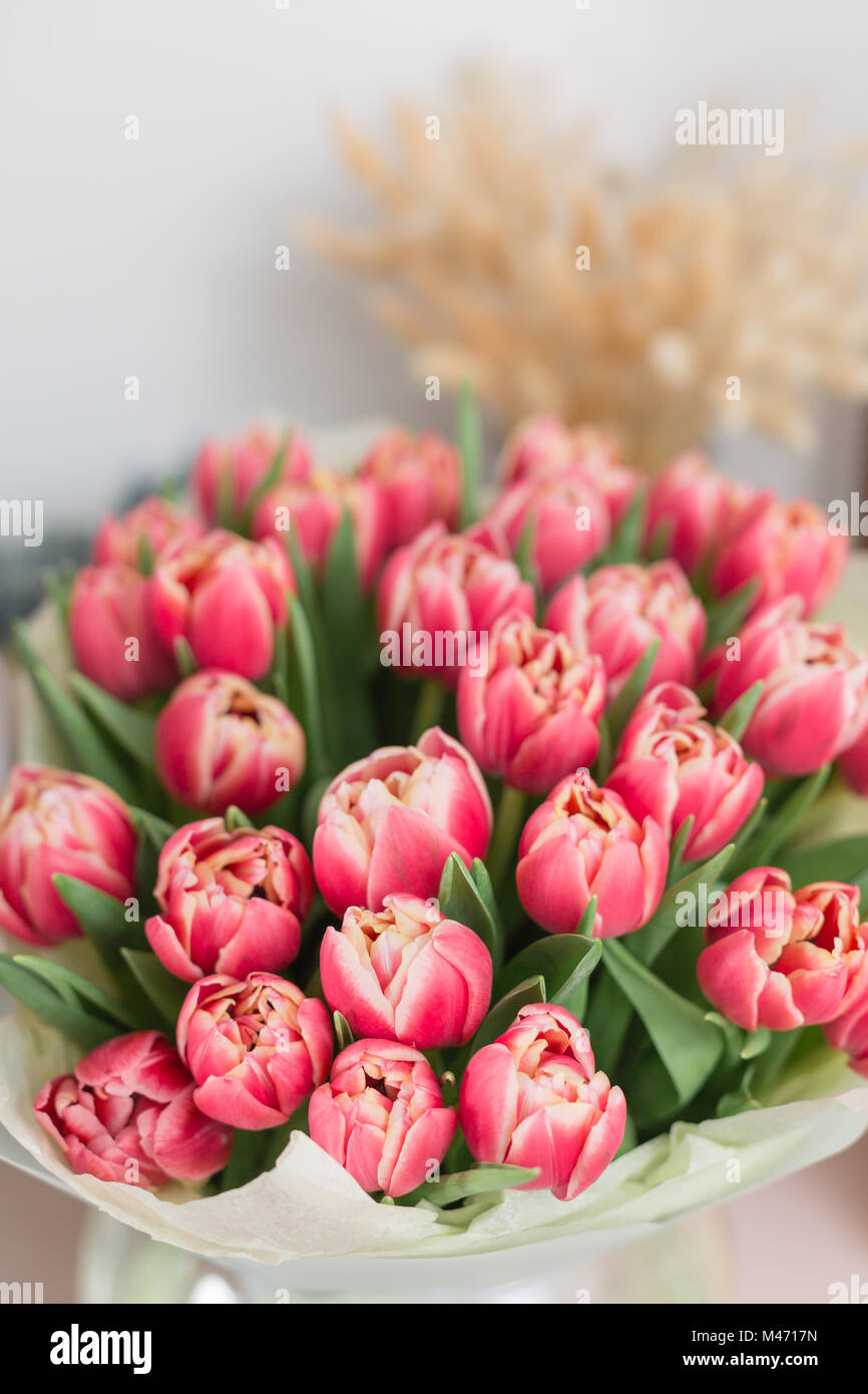 Lusso bellissimo bouquet di tulipani rosa fiori sul tavolo. Il lavoro del  fioraio presso un negozio di fiori Foto stock - Alamy