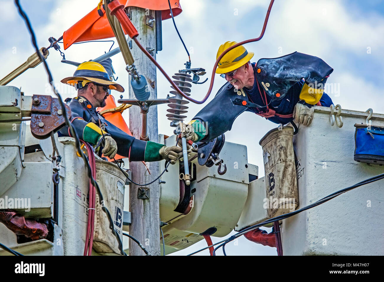 Due linemen per New Hampshire Electric Cooperative Inc. la riparazione di apparecchiature elettriche a Lisbona, NH. Foto Stock