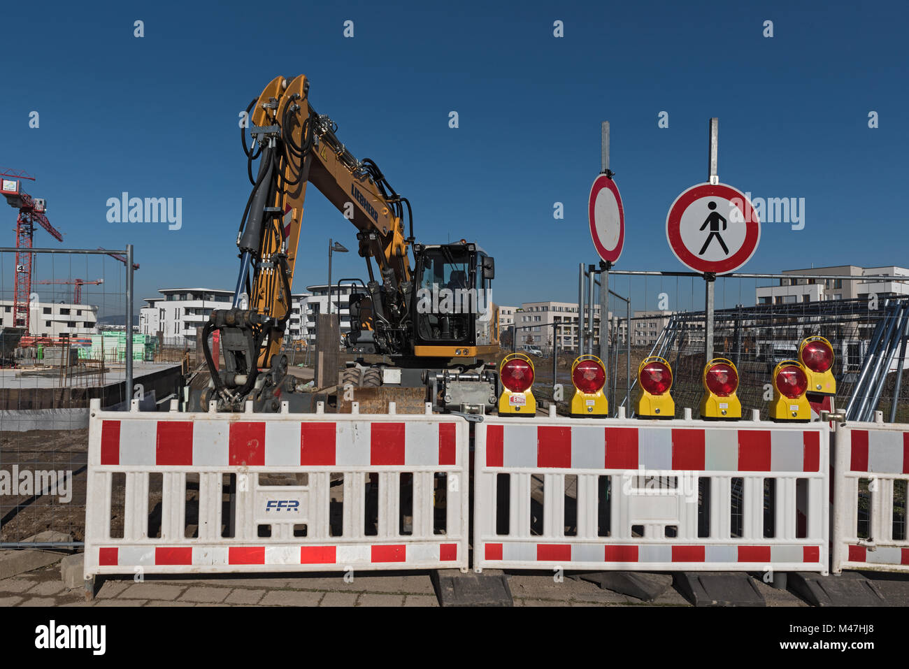 Giallo caricatore ruota dietro una struttura chiusa di ingresso del sito nel nuovo distretto di Riedberg, Francoforte, Germania Foto Stock