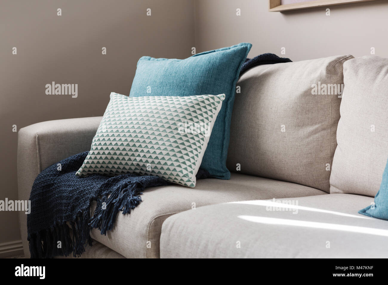 In prossimità di un tessuto divano con cuscini in stile e passi Foto Stock