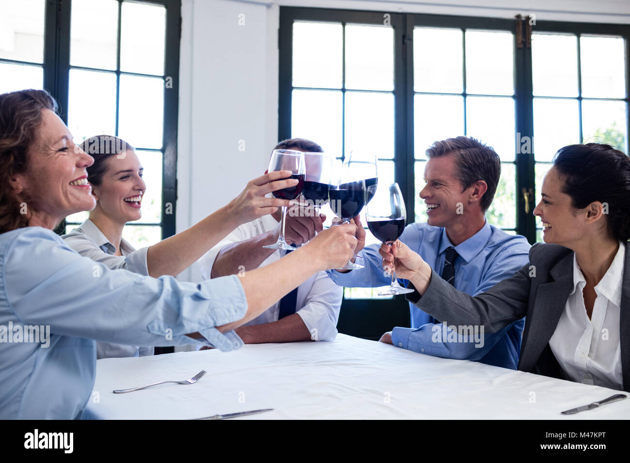 Un gruppo di imprenditori come tostare il bicchiere di vino durante il pranzo business meeting Foto Stock