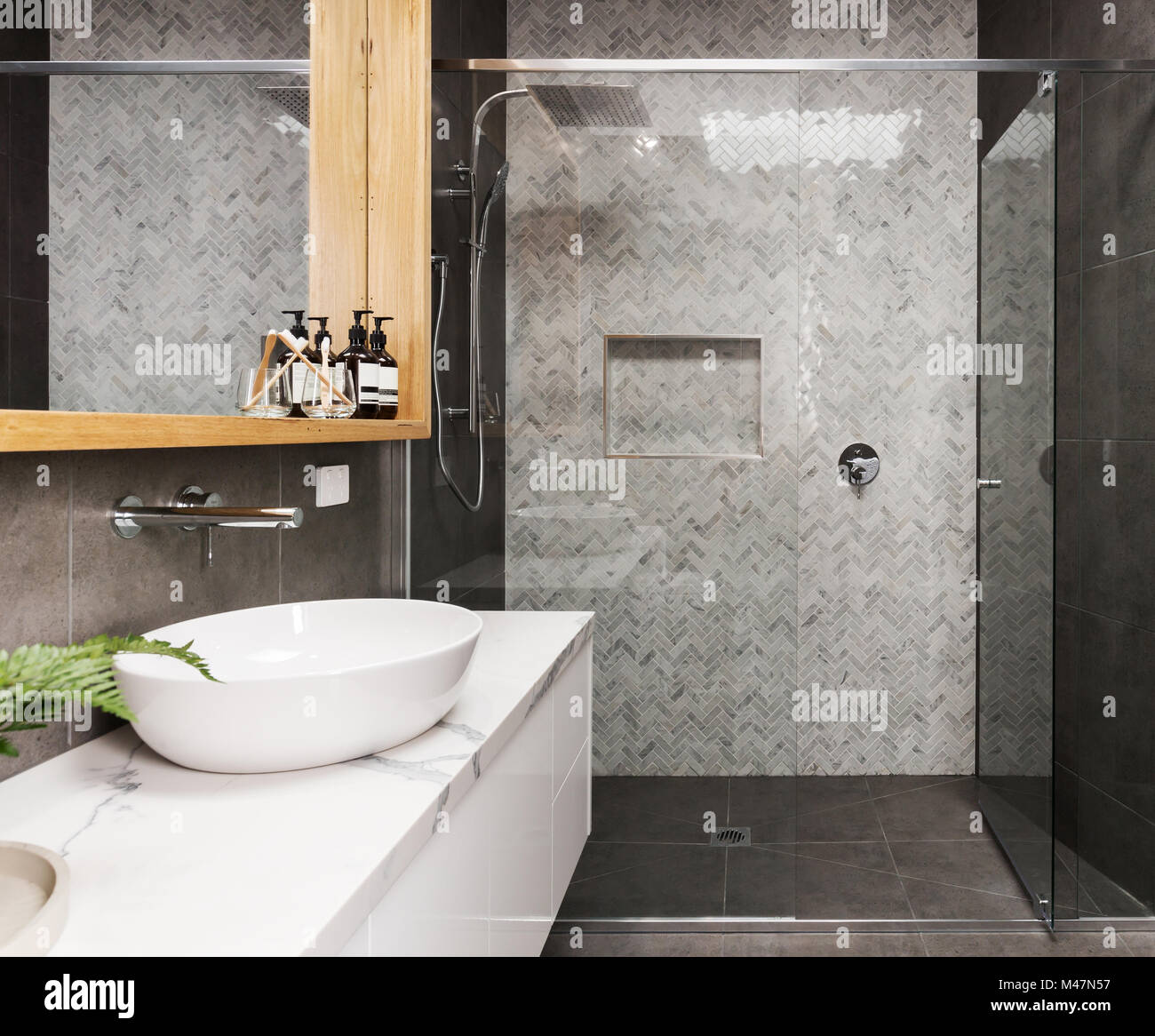Mosaico in marmo a spina di pesce doccia piastrellato parete funzione contemporanea in un bagno privato Foto Stock