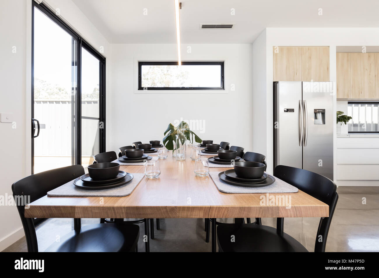Splendida cena impostazione del vasellame nero su un tavolo in legno di quercia in una casa moderna Foto Stock