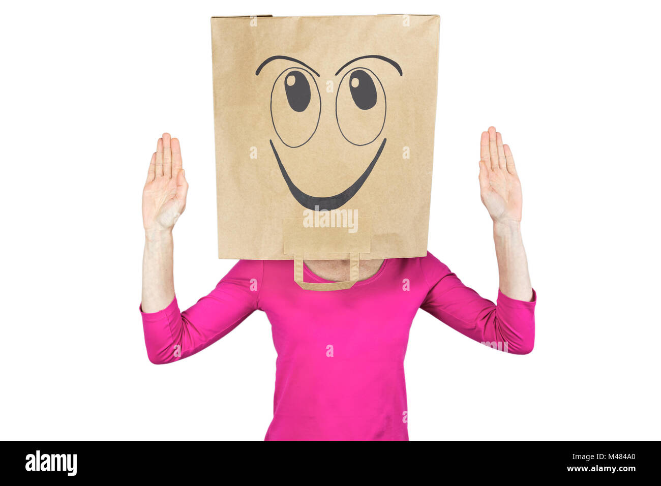Donna che indossa sacchetto di carta con felice espressione facciale sulla testa Foto Stock