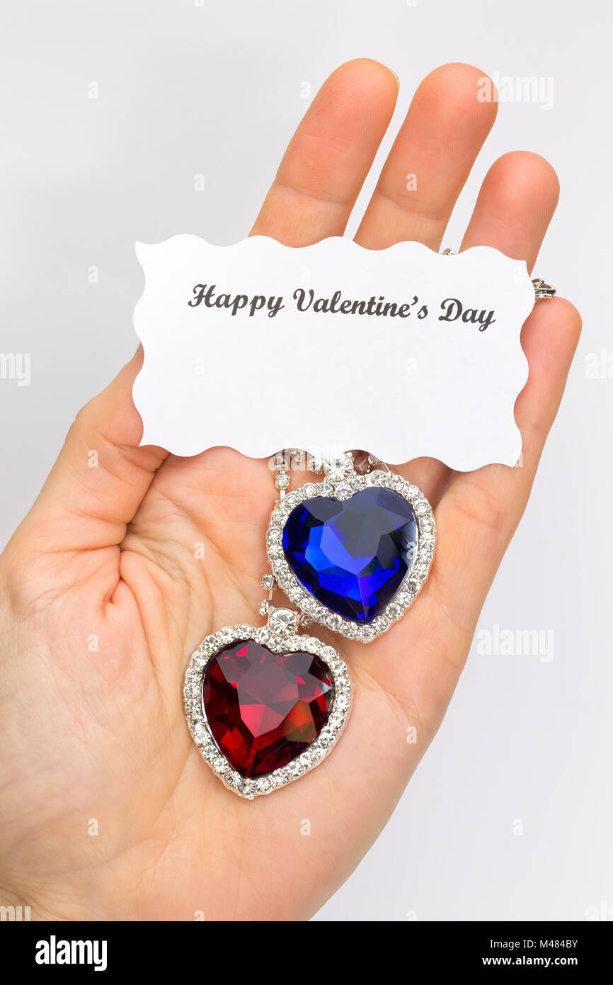 La mano che mostra il rosso e il blu gioielli cuori per San Valentino Foto Stock