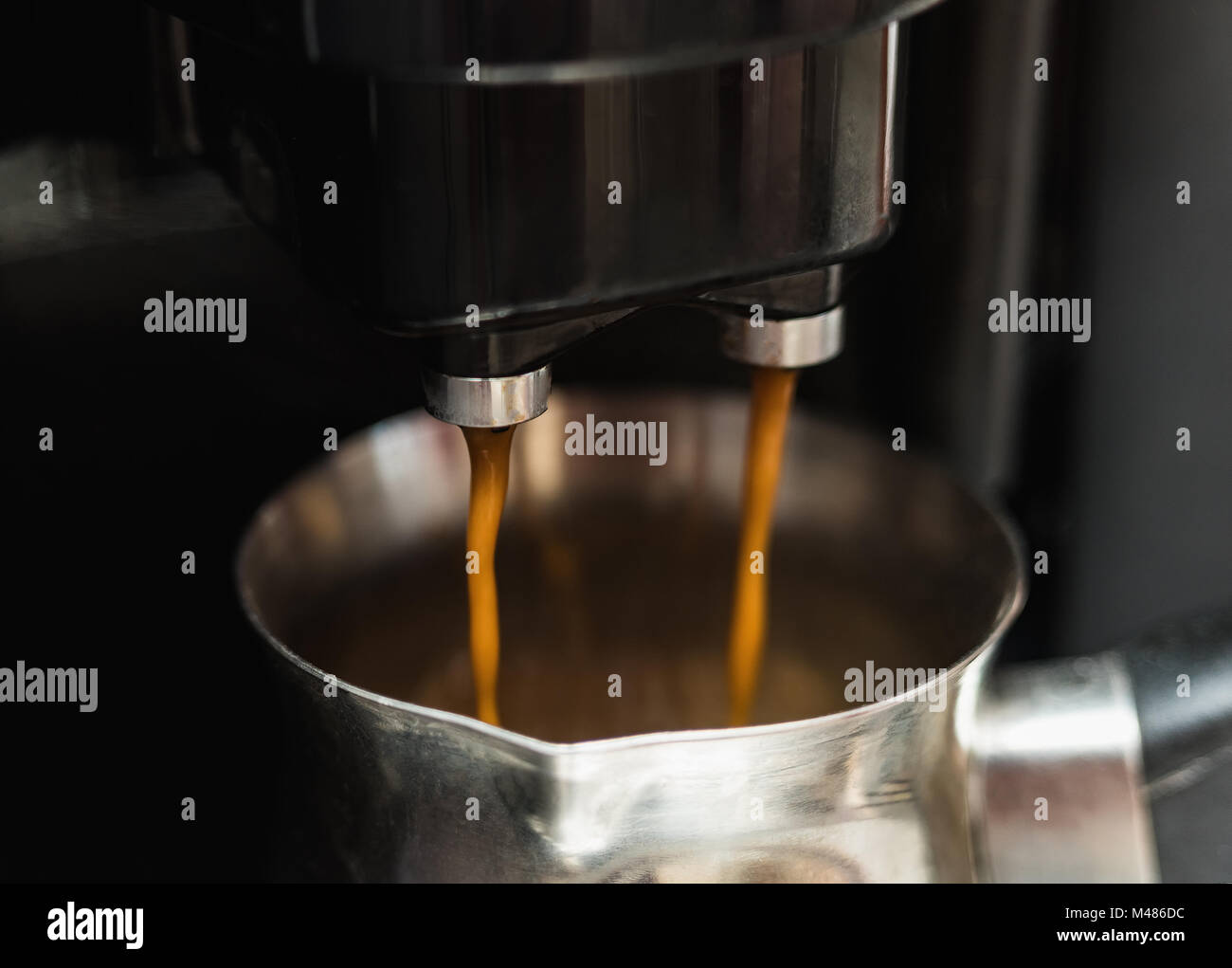 Preparazione di un doppio caffè nero in una macchina automatica Foto Stock