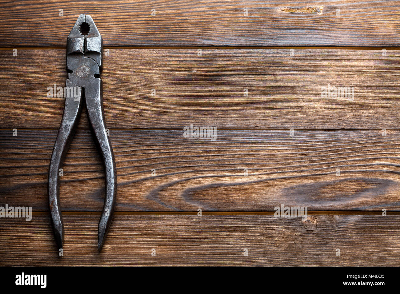 Vecchio arrugginito pinze su sfondo di legno Foto Stock