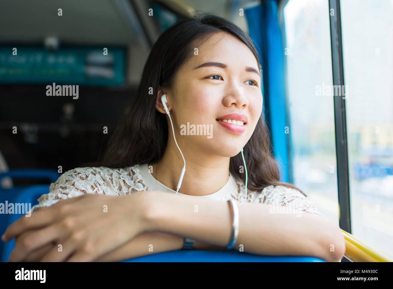 Ragazza per ascoltare musica su un pubblico di autobus Foto Stock