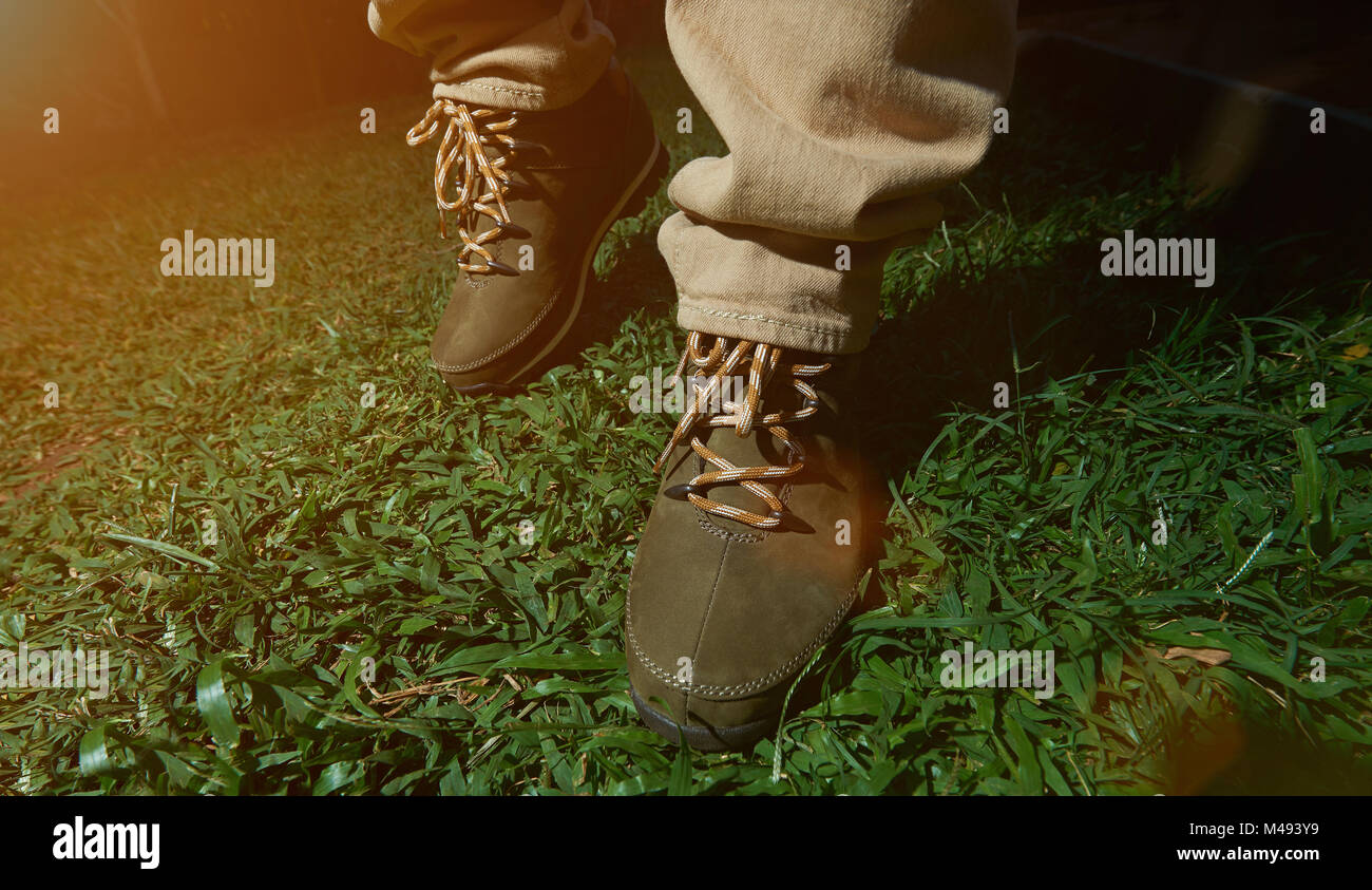 Camminando su erba verde in scarpe da escursionismo vista da davanti di close-up Foto Stock