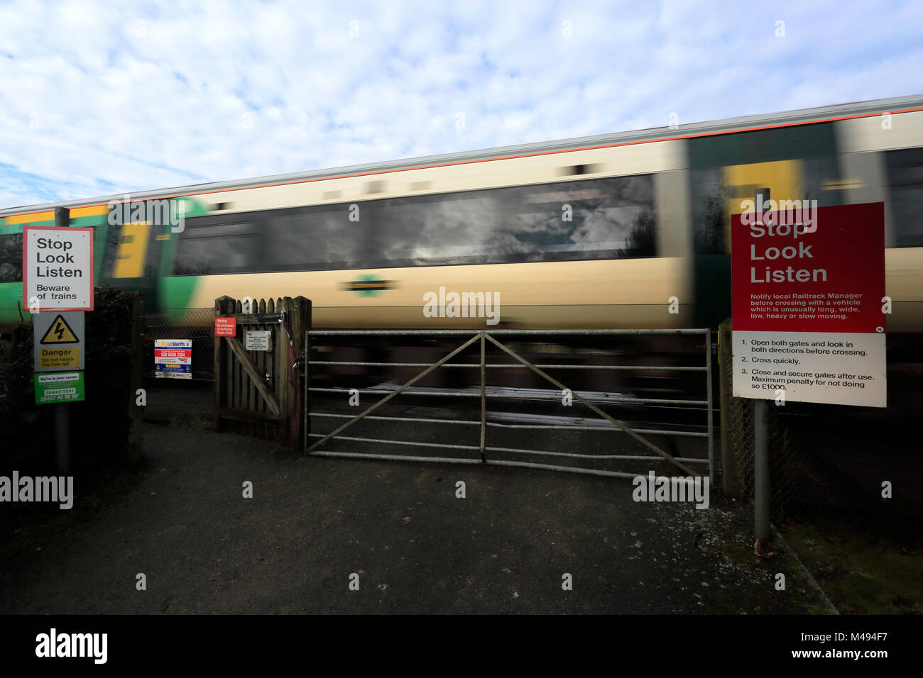 Sud della linea ferroviaria che passa un livello senza equipaggio crossing, Arundel, Sussex, England, Regno Unito Foto Stock