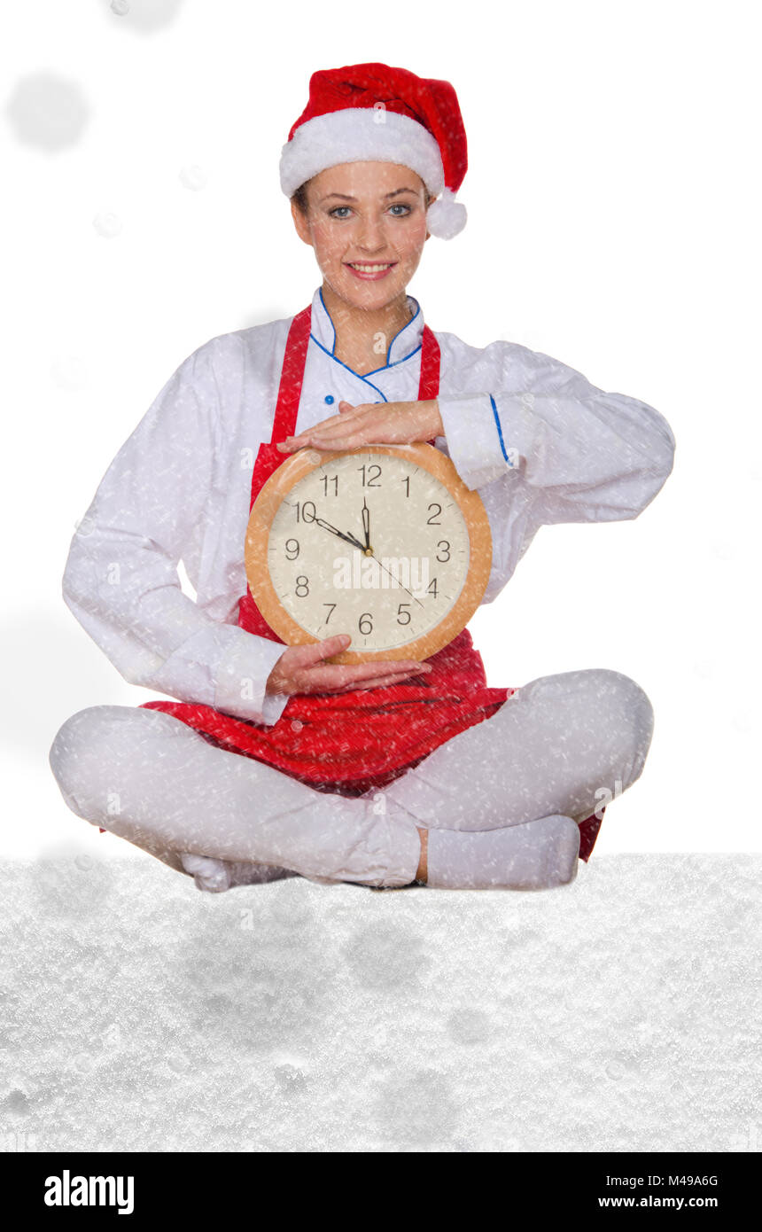 Donna cucinare in Santa hat, yoga orologio sotto neve Foto Stock