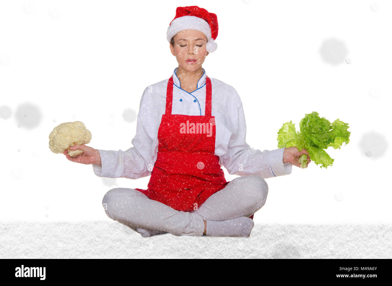 Cuocere in Santa hat, yoga, verdure sotto neve Foto Stock
