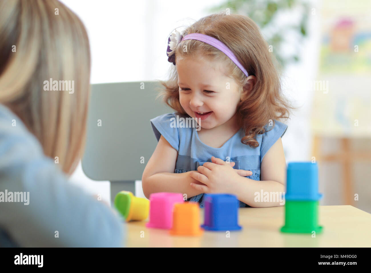La madre e il bambino giocando blocco colorato giocattoli a casa Foto Stock