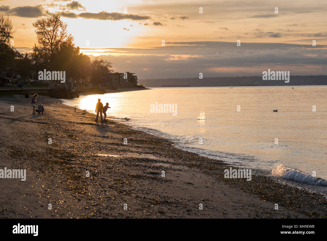 Stati Uniti, Washington, Seattle, Alki Beach, bambini che giocano sulla spiaggia al tramonto. Foto Stock