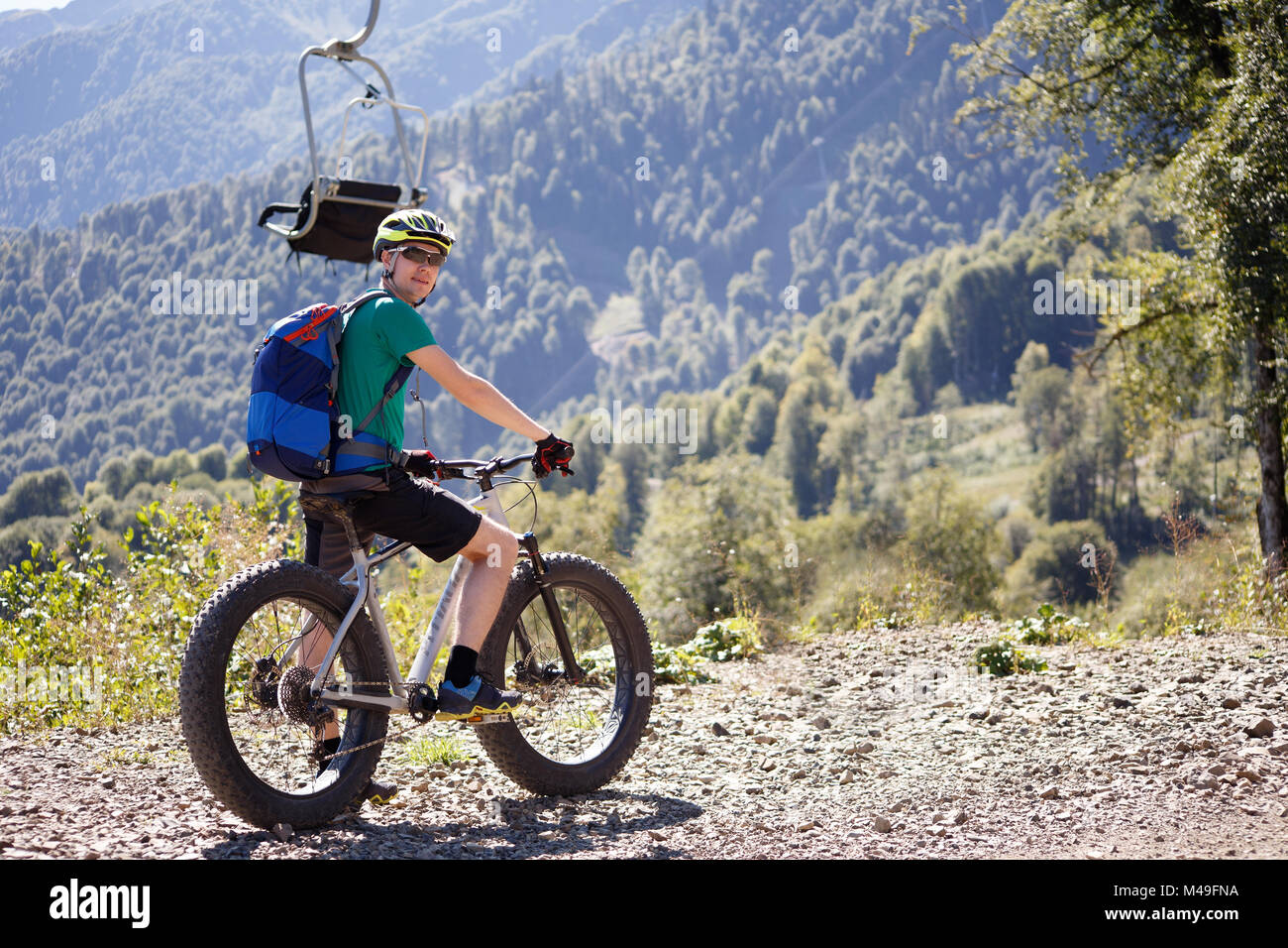 Immagine dal retro del turista maschio nel casco in bicicletta Foto Stock