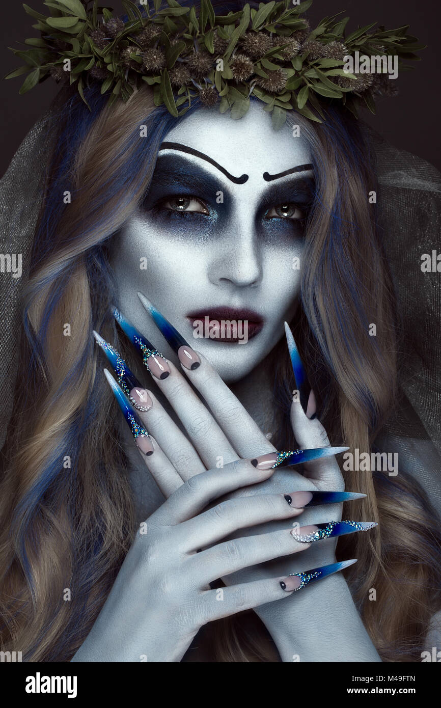Ritratto di un orribile scary Corpse Bride a corona con fiori morti, Halloween trucco e manicure lungo.Design di chiodi Foto Stock