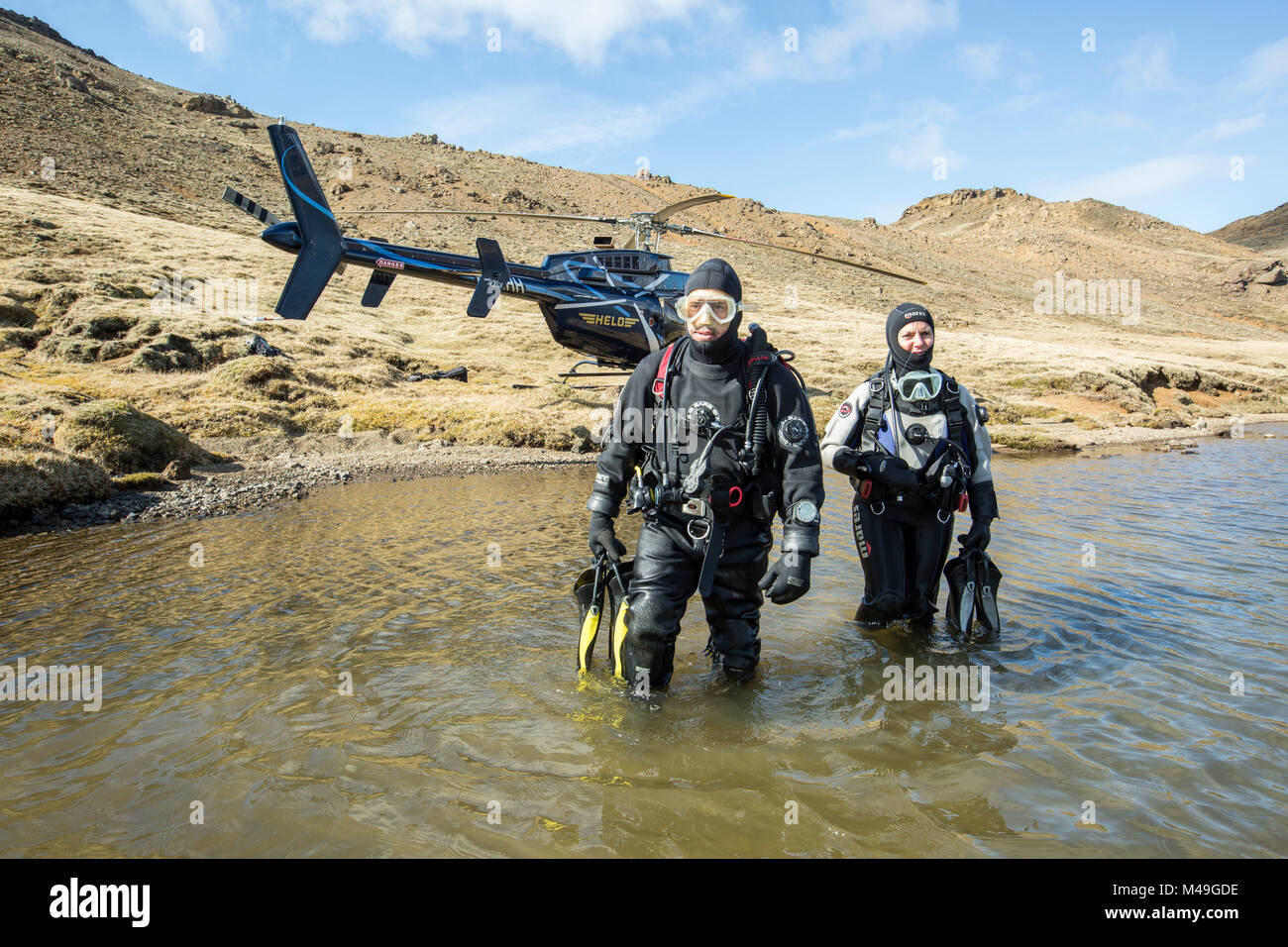 Heli-diving, entrare in acqua per un scouting immersioni in un lago di montagna, Islanda Foto Stock