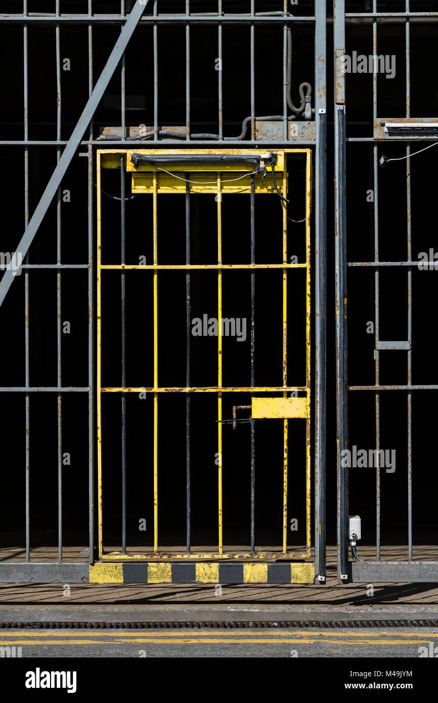 Un cancello di sicurezza giallo in una recinzione metallica, Regno Unito Foto Stock