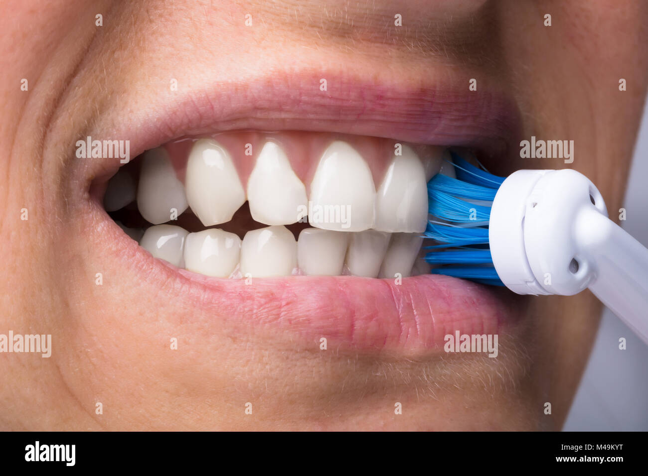 Close-up di una donna di denti con spazzolino da denti elettrico Foto Stock