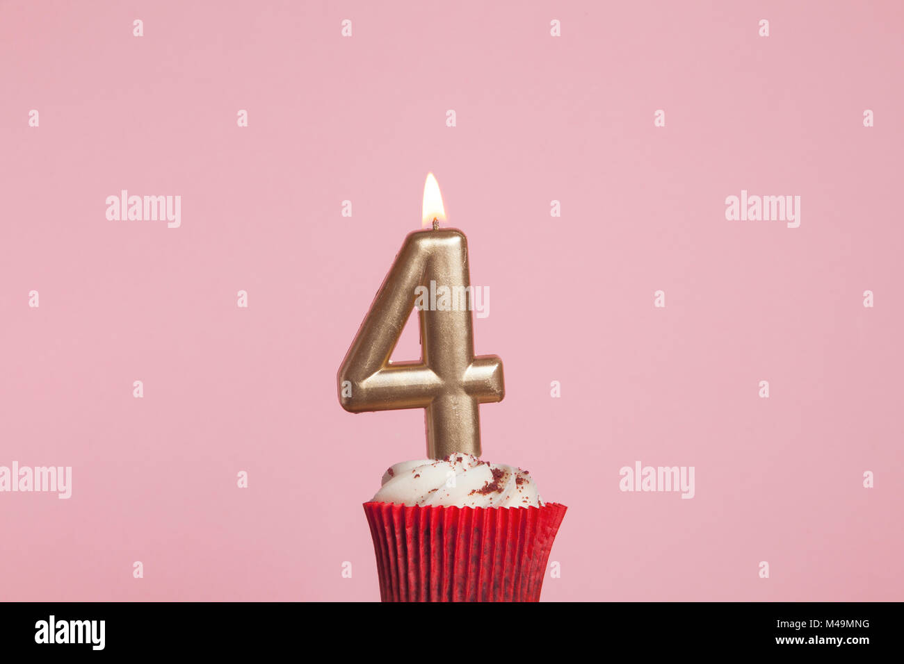 Numero 4 oro candela in una tortina contro un pastello sfondo rosa Foto Stock