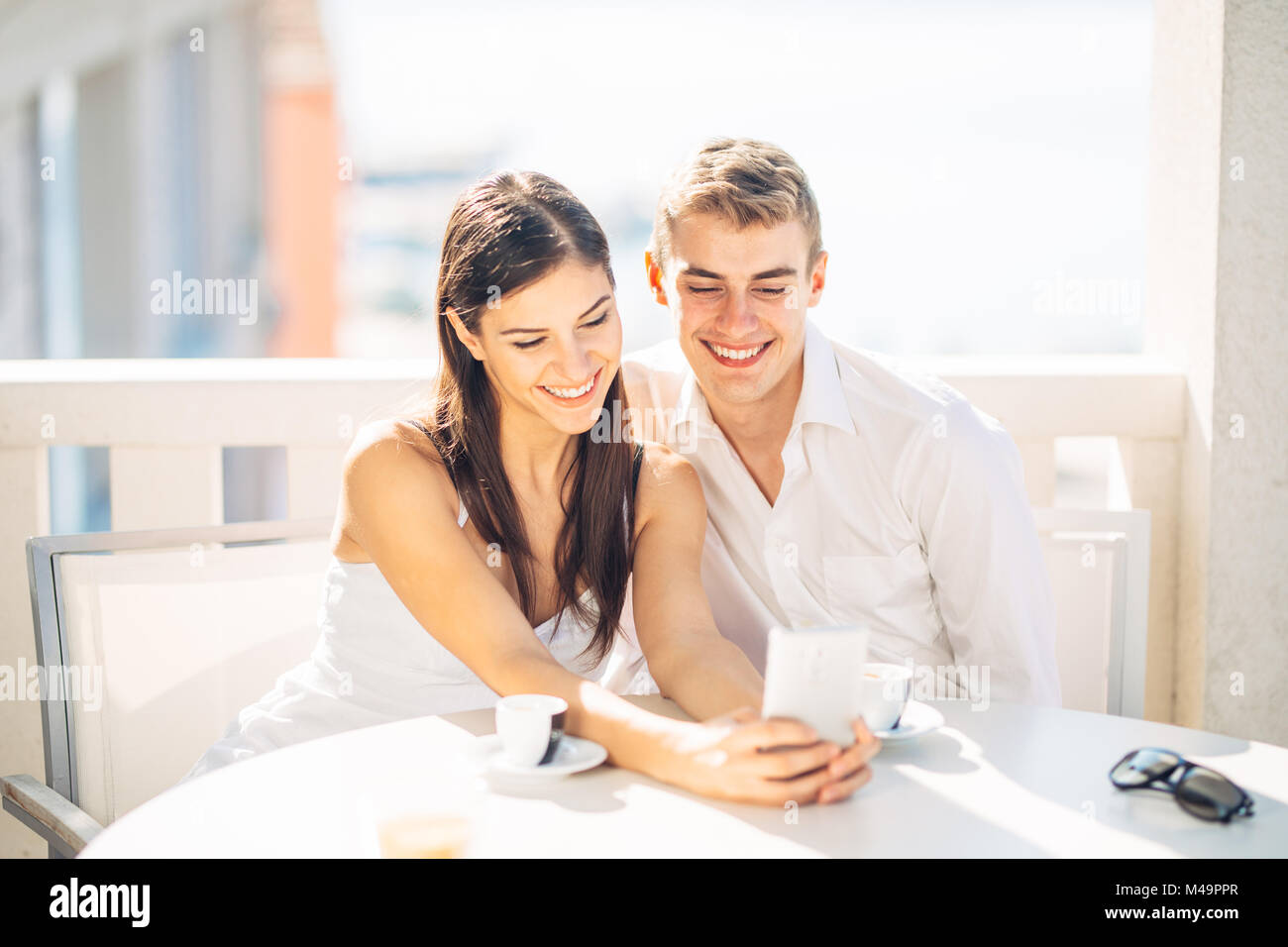 Coppia attraente avente prima data.Il caffè con un amico.sorridono felici le persone facendo una selfie.condividere sui social media.mostra il contenuto sullo smartphone Foto Stock