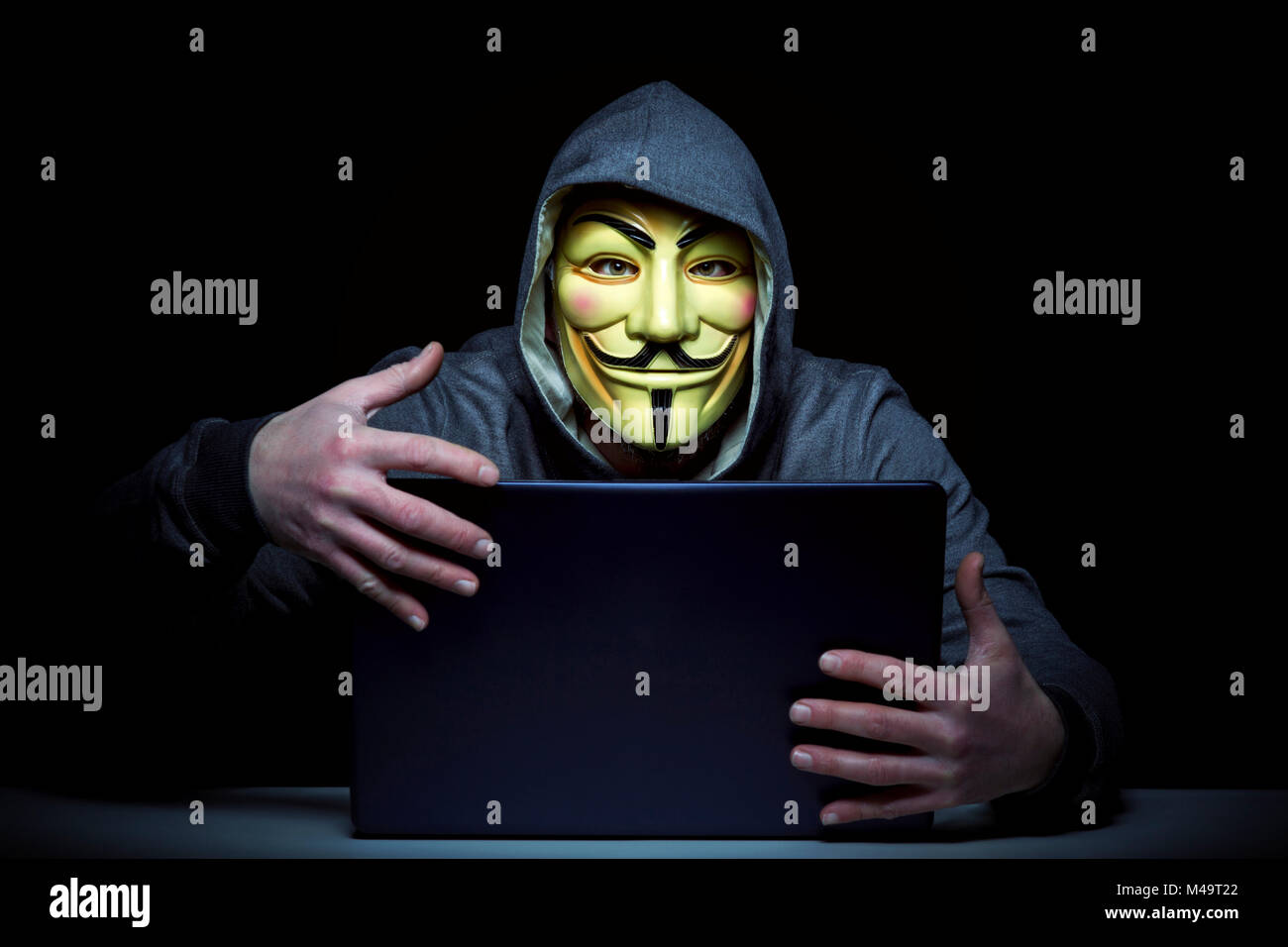 Milano,Italia, Febbraio 2018: Hacker indossare maschera anonimi con i notebook nel buio .foto editoriale. Foto Stock