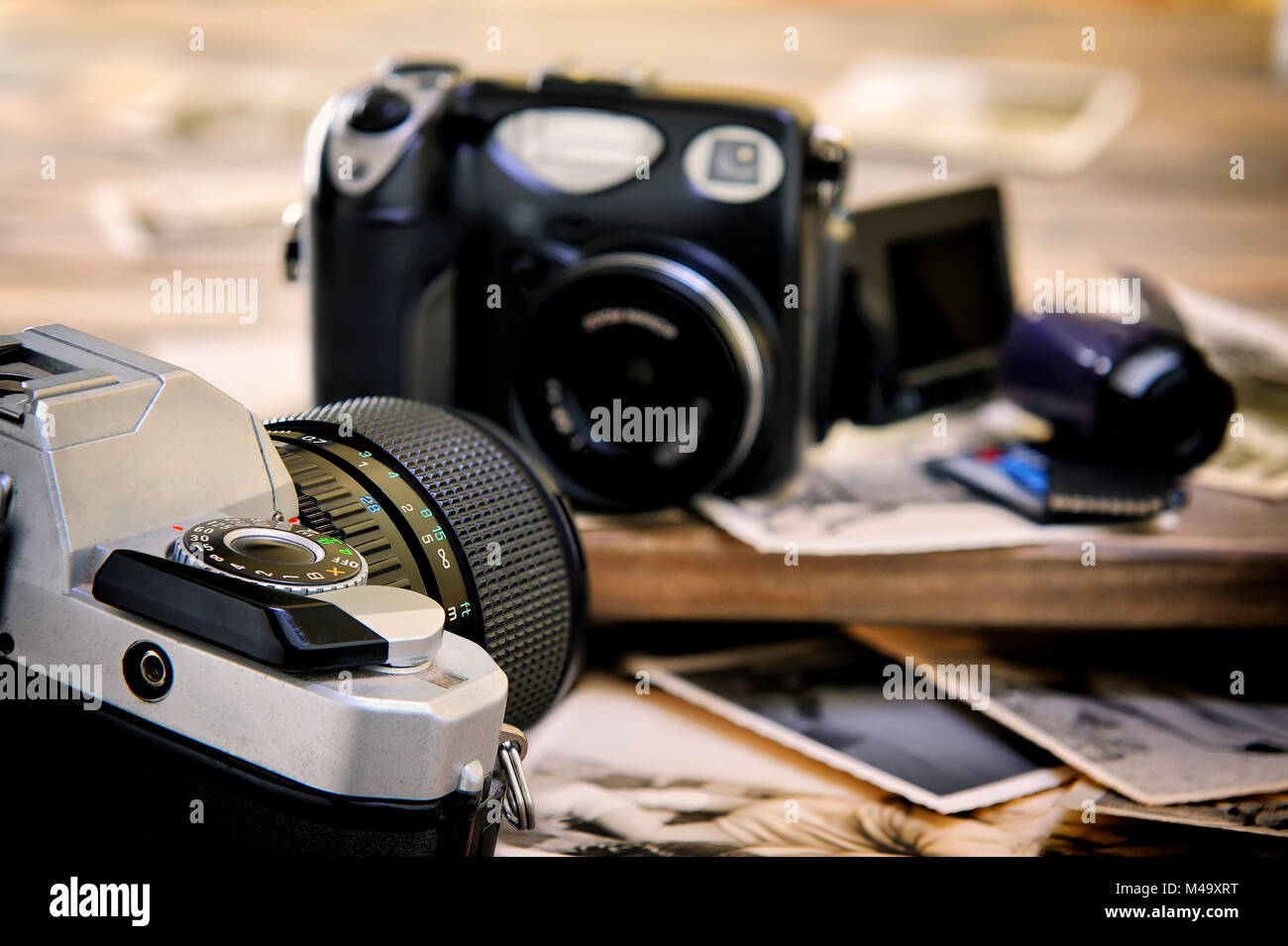 Primo piano di vintage stampe fotografiche, film e fotocamera digitale compatta di età su sfondo di legno. Foto Stock