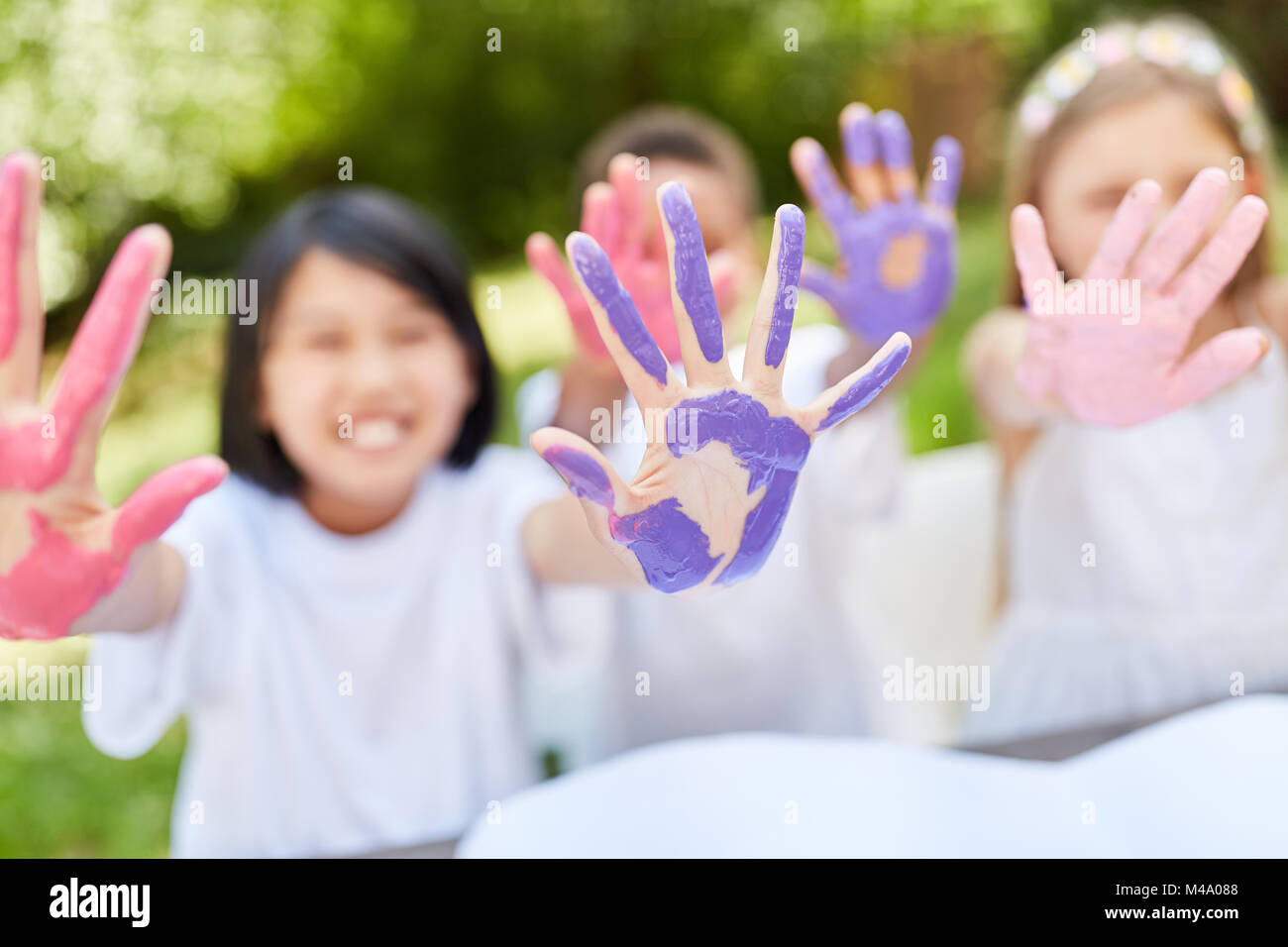 I bambini giocando a dipingere con il dito dipinge su una festa di compleanno di bambini Foto Stock