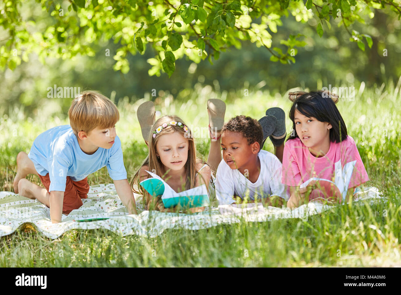 Scuola elementare gruppo multiculturale dei bambini imparare insieme nel parco Foto Stock