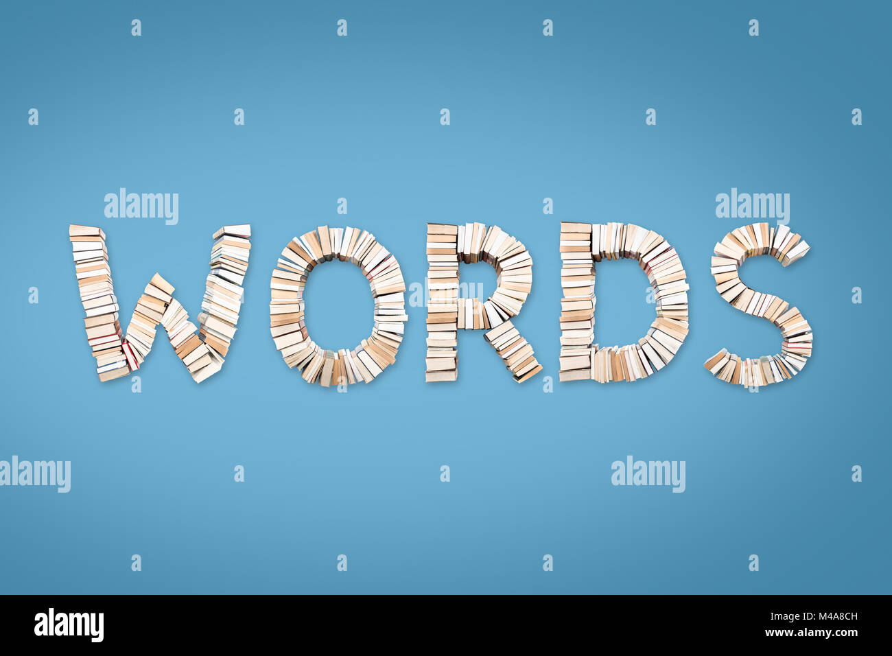 Parole parola formata da libri, ripresa dall'alto su fondo azzurro Foto Stock