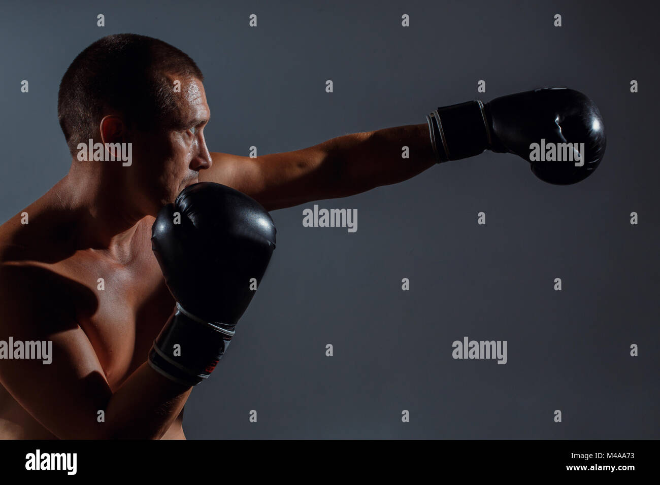 La boxe fighter formazione indoor su sfondo grigio Foto Stock