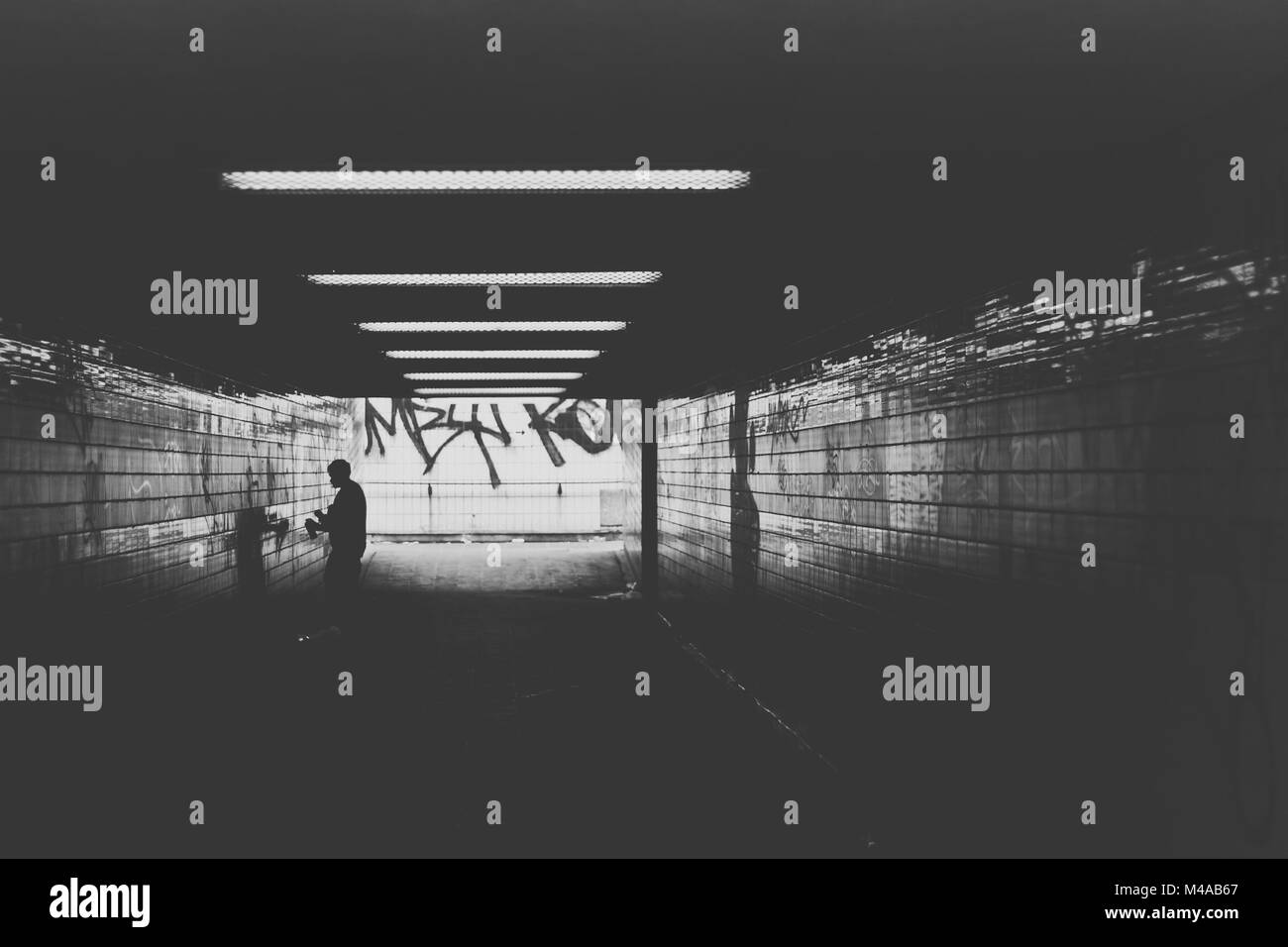 Artista di graffiti nel tunnel Foto Stock