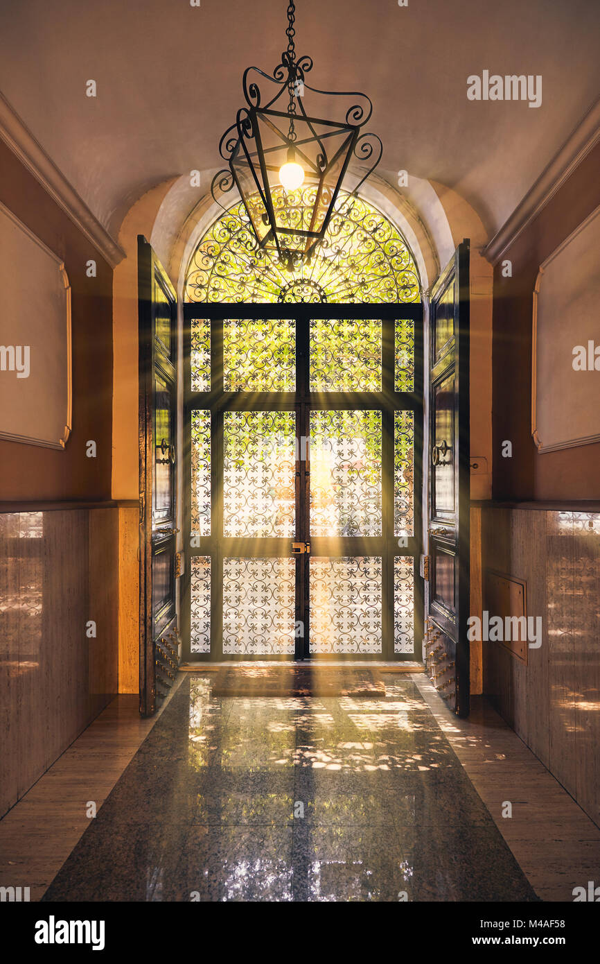 Bella italiana di vetro porta anteriore con ornamenti decorativi da metallo, vista dall'interno. La porta è illuminata dai raggi del sole da la stre Foto Stock