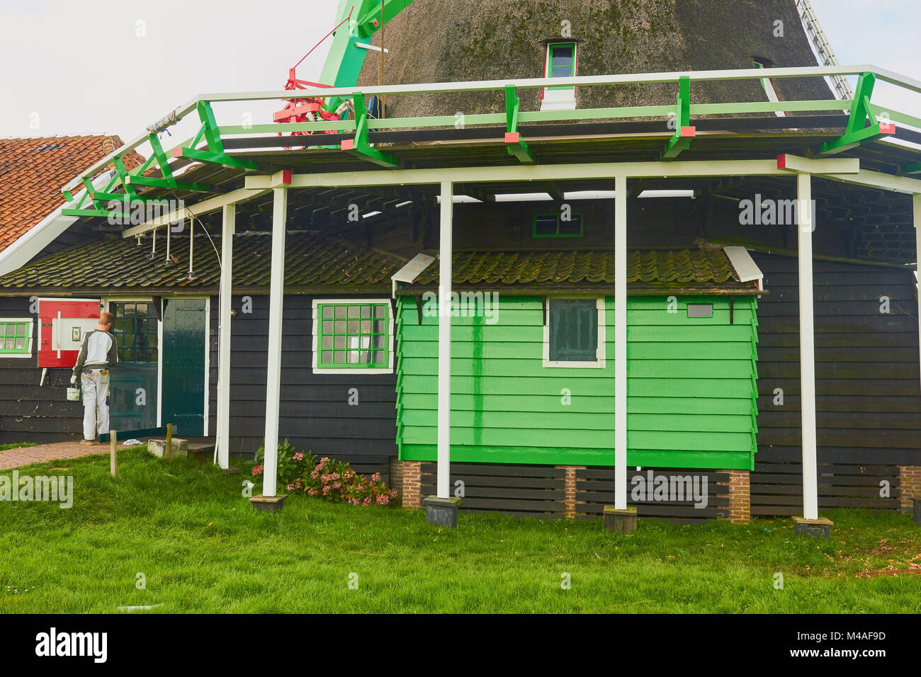 Uomo di pittura, il mulino a vento di Zaanse Schans un villaggio nei pressi di Zaandijk nel comune di Zaanstad, North Holland, Paesi Bassi. Foto Stock