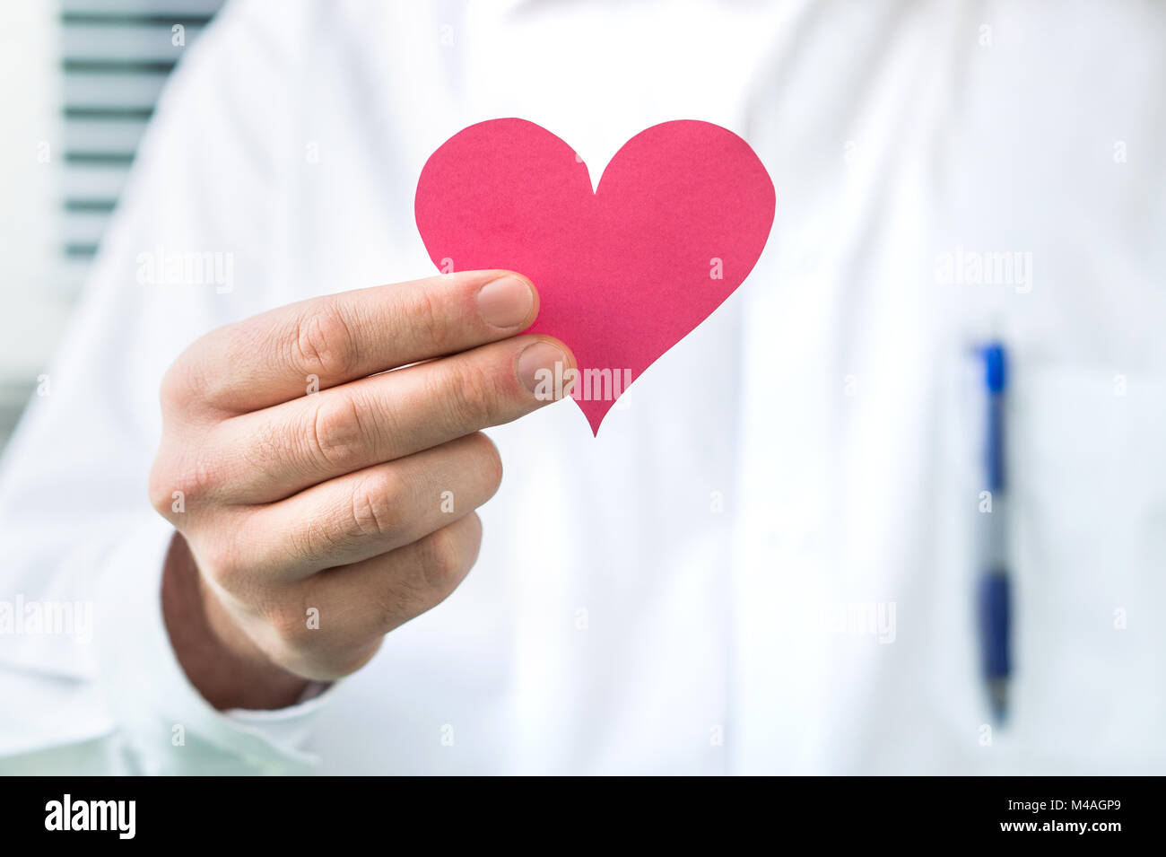Medico tenendo cuore rosso. Alta pressione sanguigna, attacco di cuore o di malattia concetto. Foto Stock