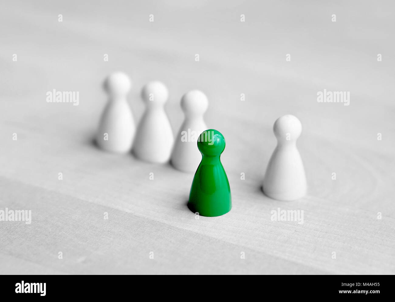 Il volontariato, coraggio ed essendo iniziativa spontanea o concetto. Il coraggio di essere diversi. Un gioco di bordo pedina stand davanti alla folla. Foto Stock